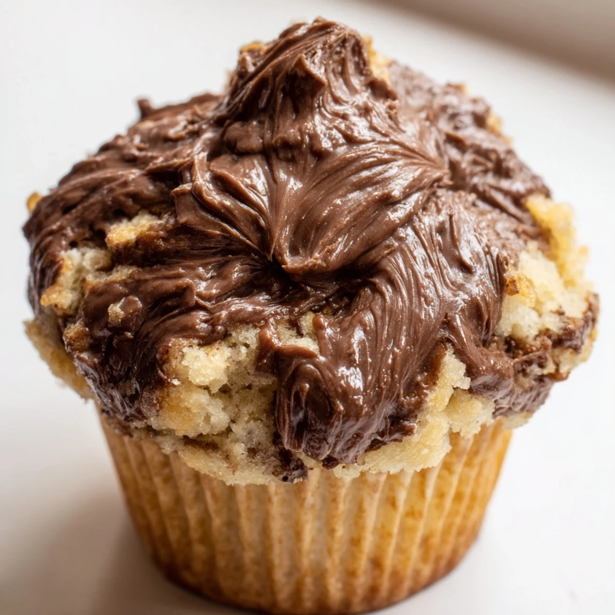 Warm homemade muffins showcasing ripe banana batter swirled with rich chocolate hazelnut spread