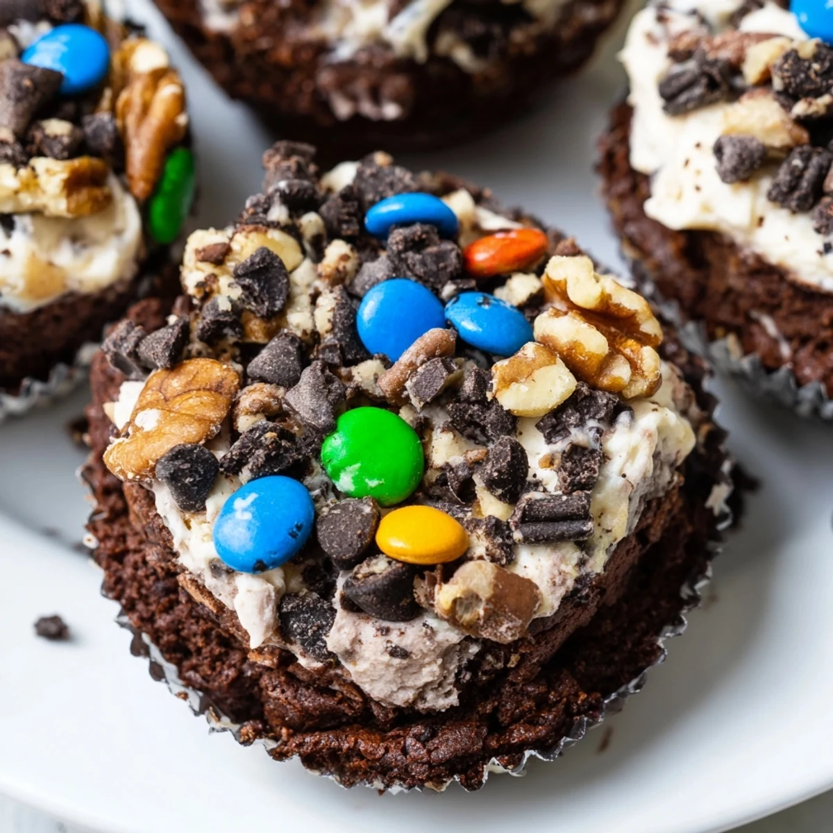 Rich fudgy loaded brownie cheesecake cups topped with colorful sprinkles and crunchy chocolate chips