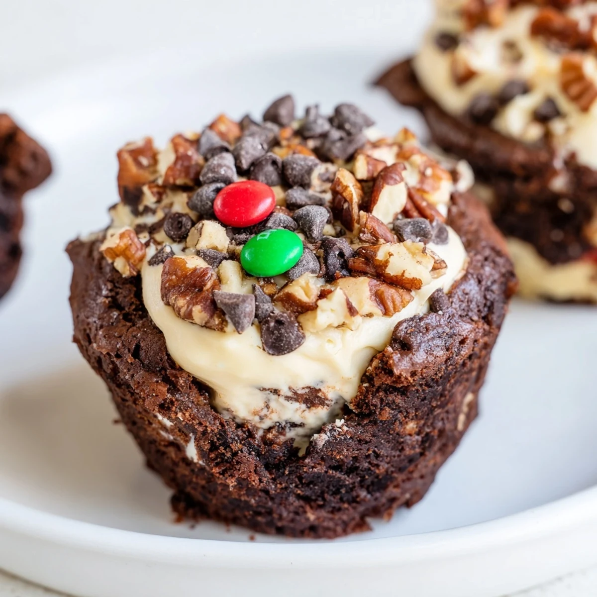 Individual loaded brownie cheesecake cups featuring creamy vanilla cheesecake swirled with dark chocolate brownie layers