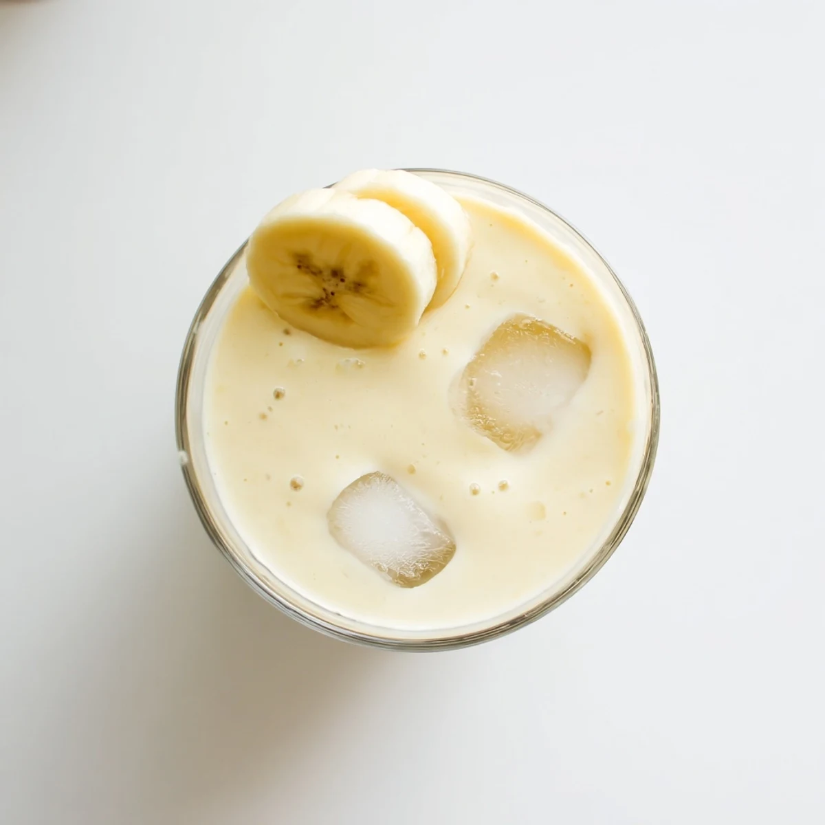 Golden Greek yogurt banana smoothie poured into tall glasses with cinnamon garnish