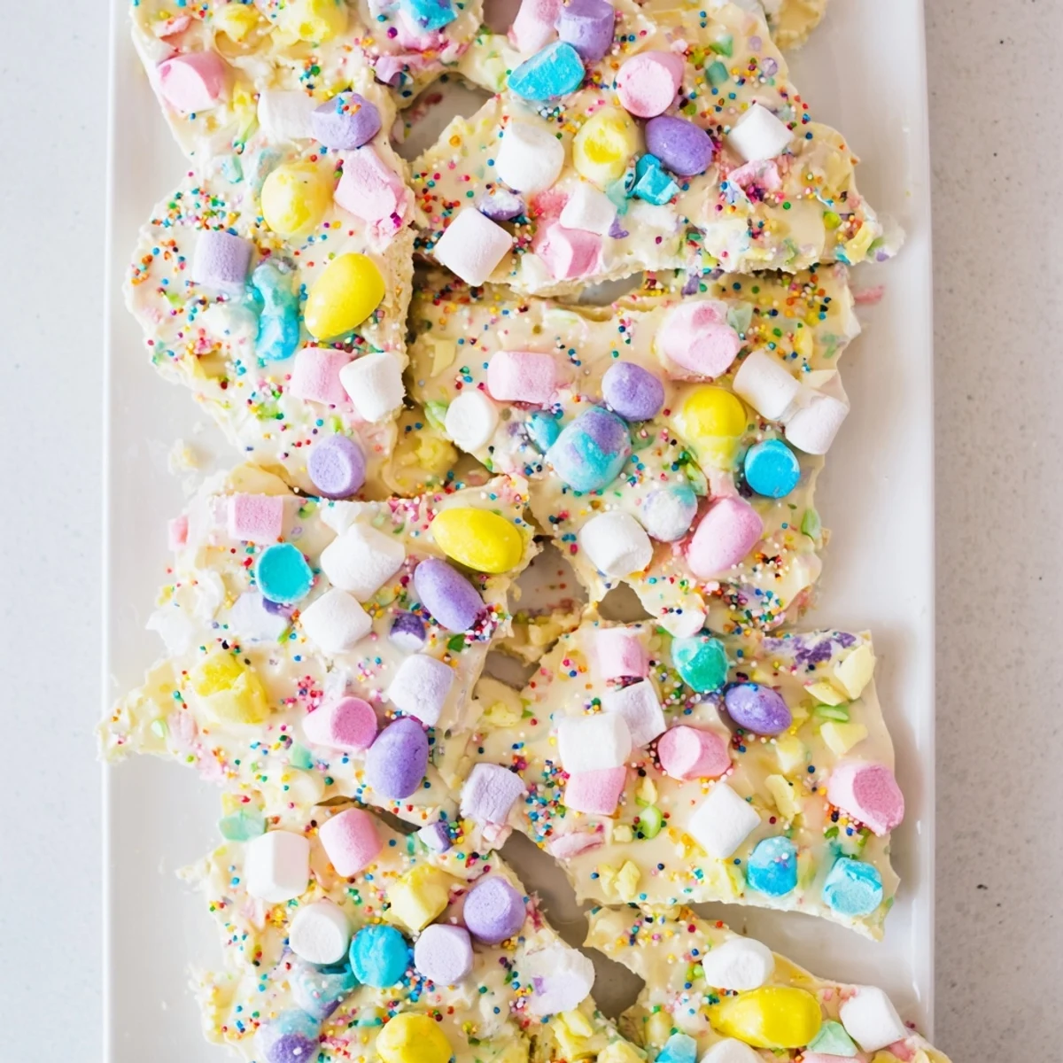 Creamy white chocolate Easter Marshmallow Bark topped with colorful sprinkles and chopped chocolate eggs