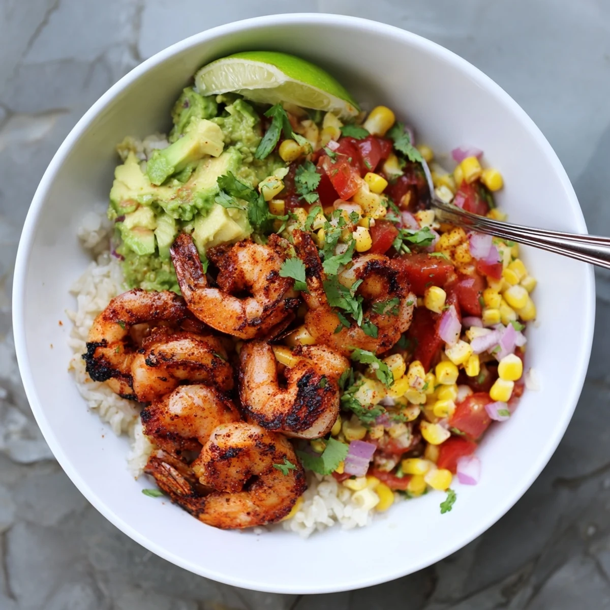 Charred grilled shrimp bowl with avocado corn salsa over fluffy white rice
