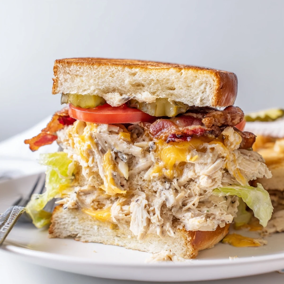 Creamy Crack Chicken Sandwiches topped with crispy bacon and dill pickle slices