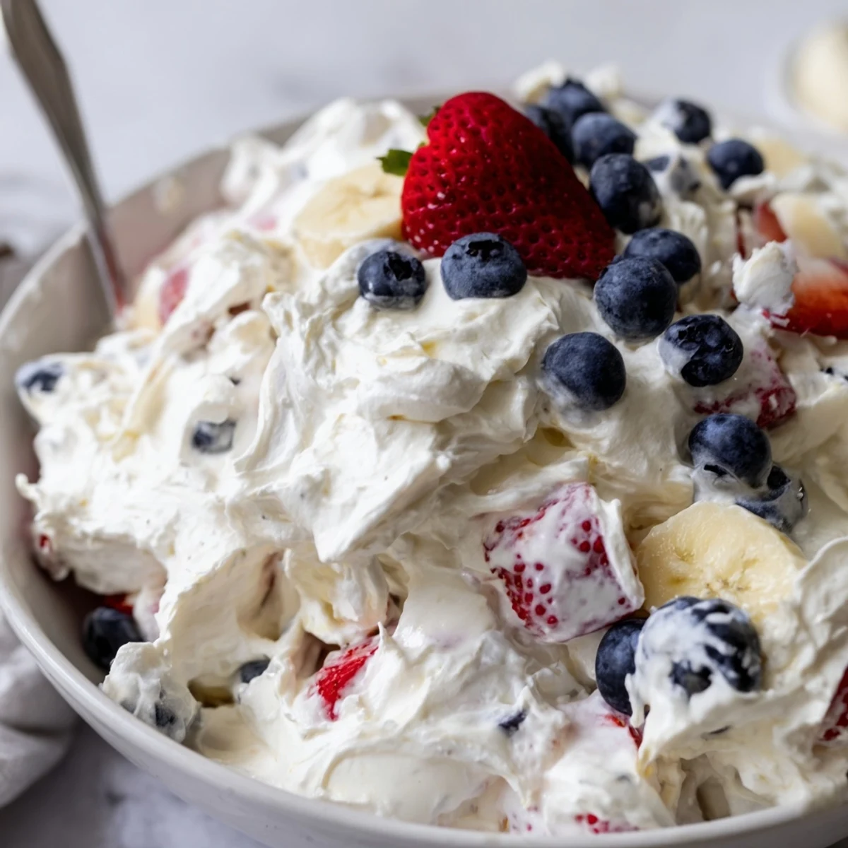 Red White And Blue Cheesecake Salad with creamy filling, juicy berries, chilled.
