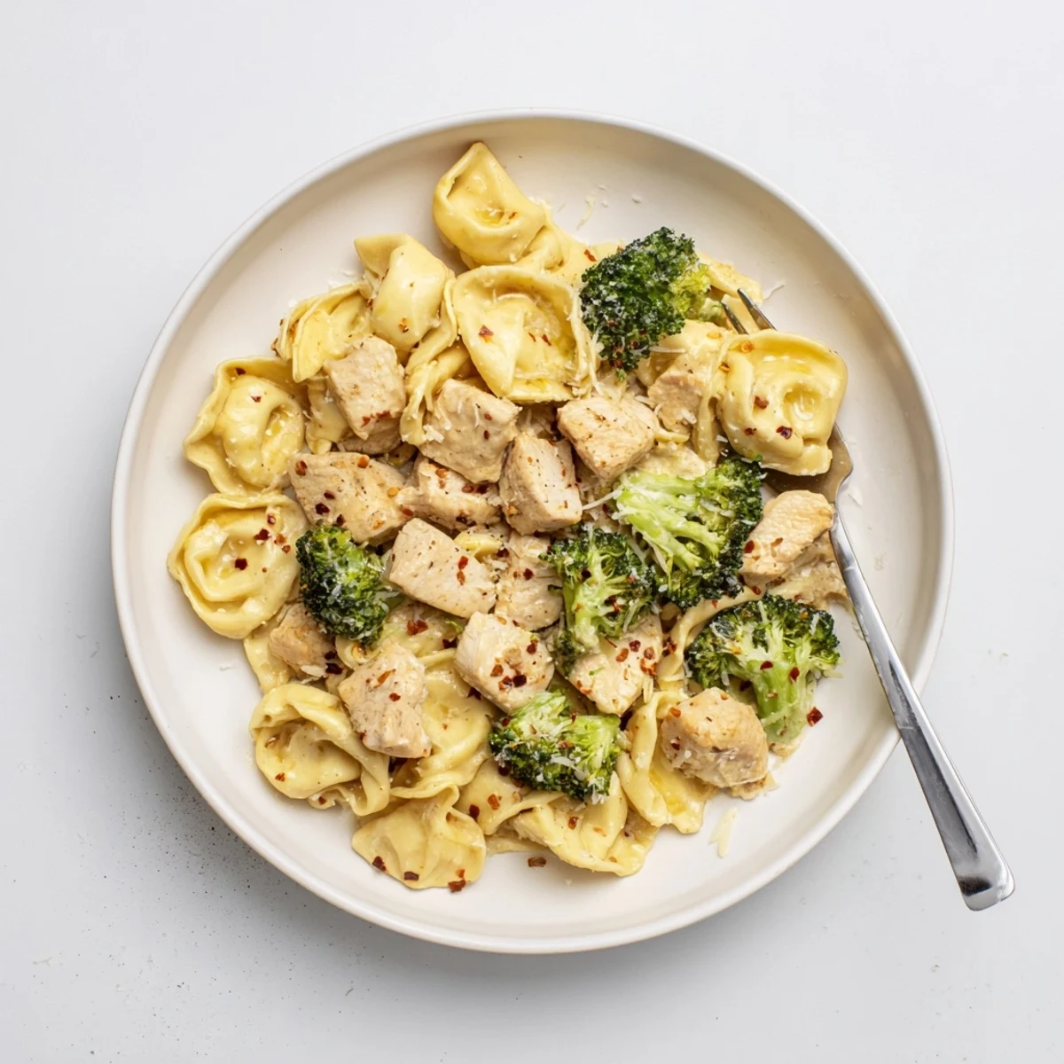 Creamy Garlic Parmesan Tortellini Chicken Broccoli Recipe plated steaming, silky sauce, golden chicken