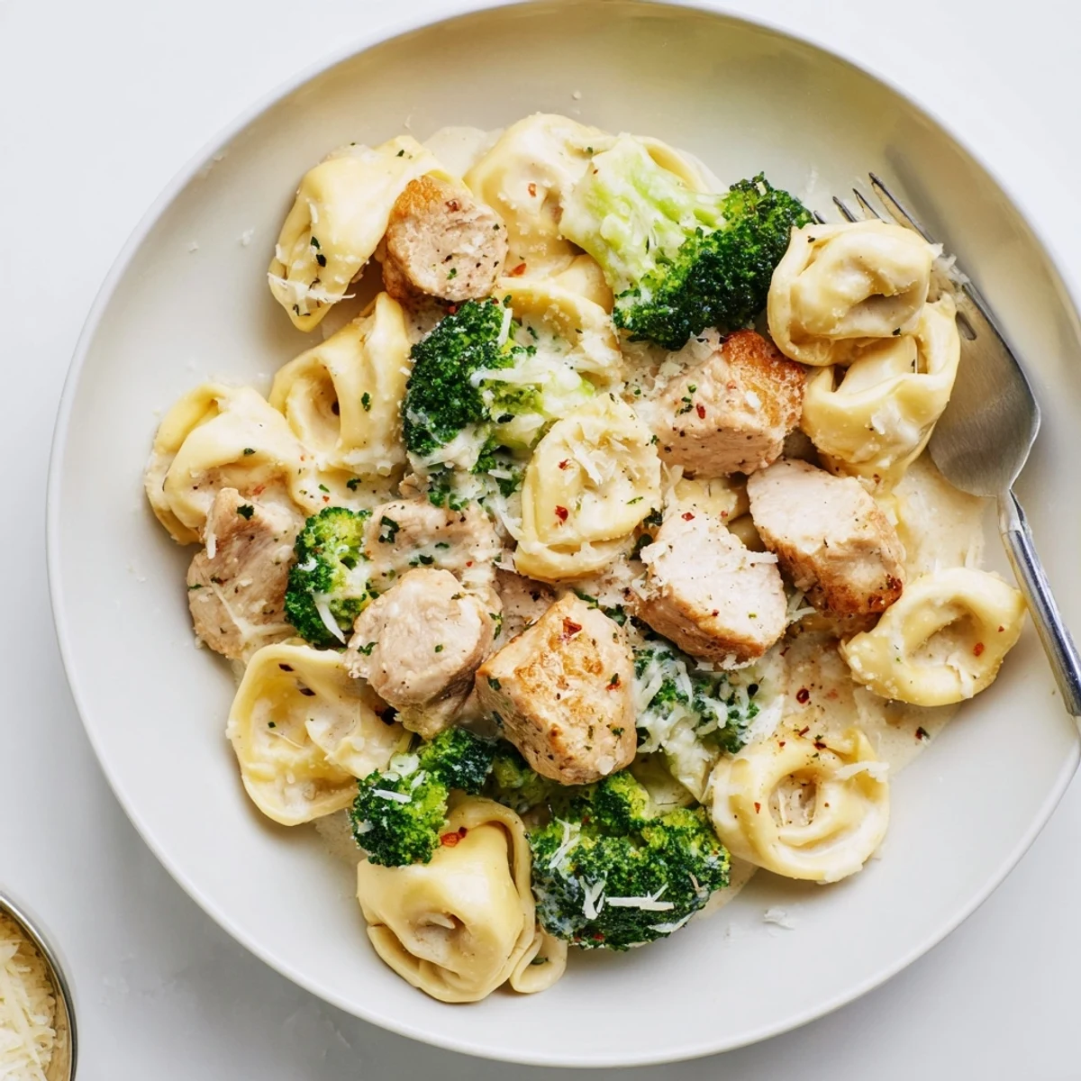Warm Creamy Garlic Parmesan Tortellini Chicken Broccoli Recipe in shallow bowl, tender bites