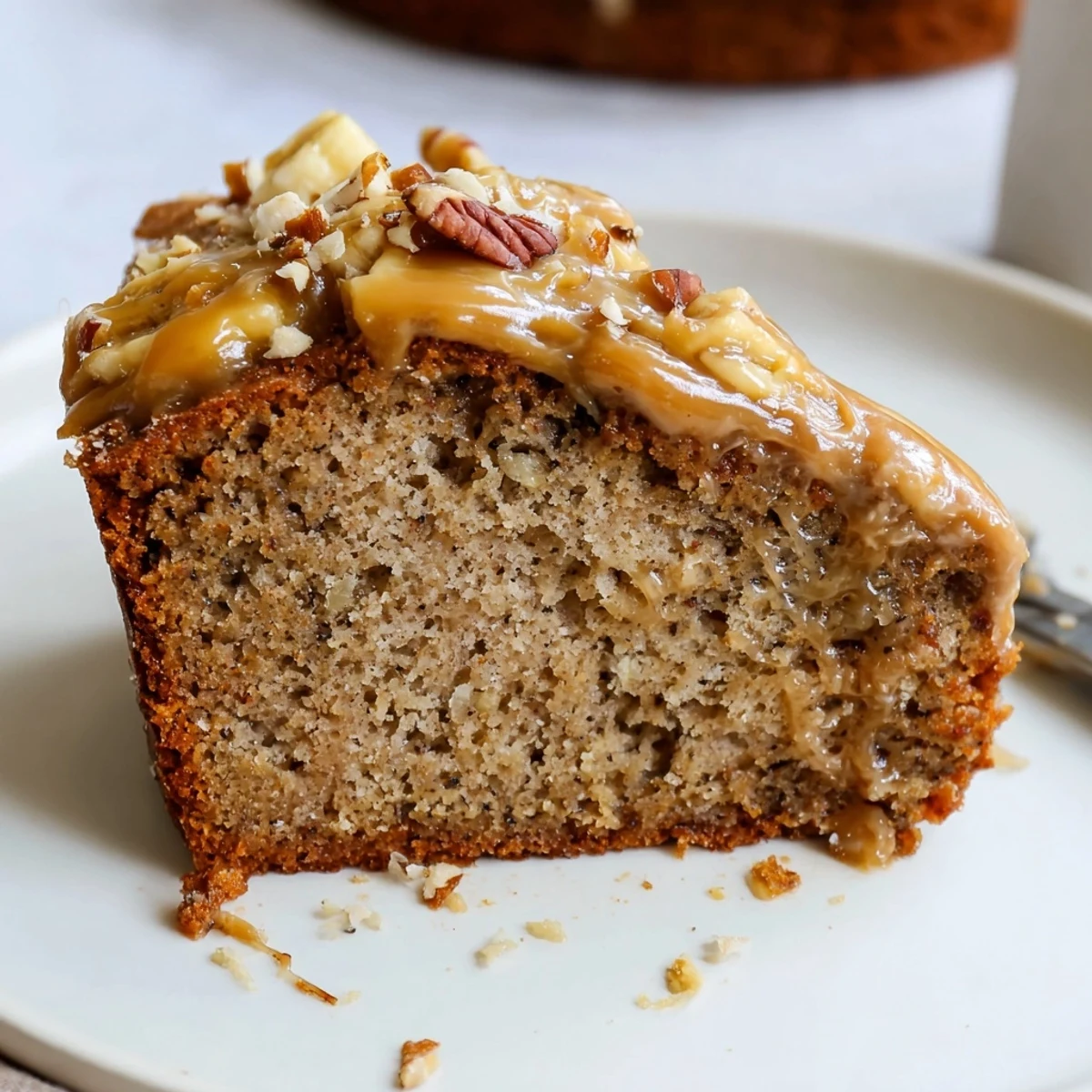 Moist Salted Caramel Brown Butter Banana Cake sliced, warm, topped with toasted pecans
