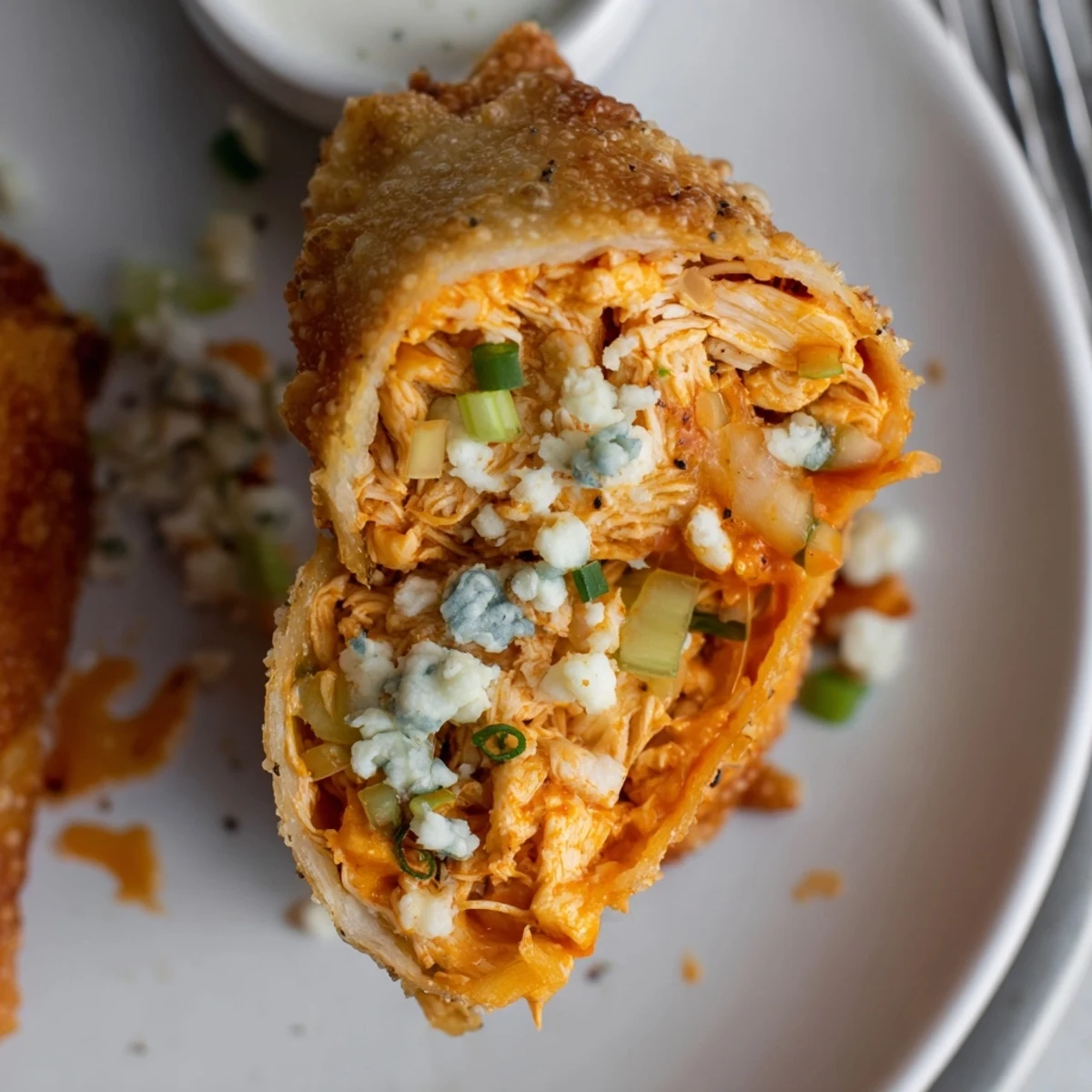 Steaming Buffalo Chicken Egg Rolls split open showing melty cheese, spicy filling  
