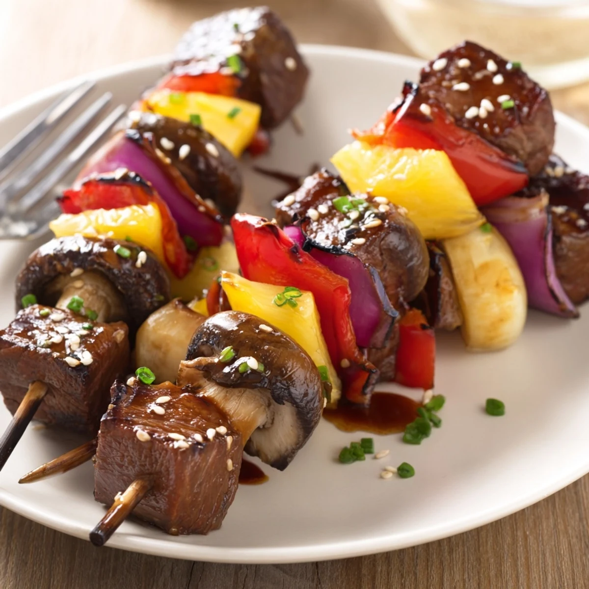 Juicy Grilled Teriyaki Steak Kabobs on skewers, charred onion and pineapple