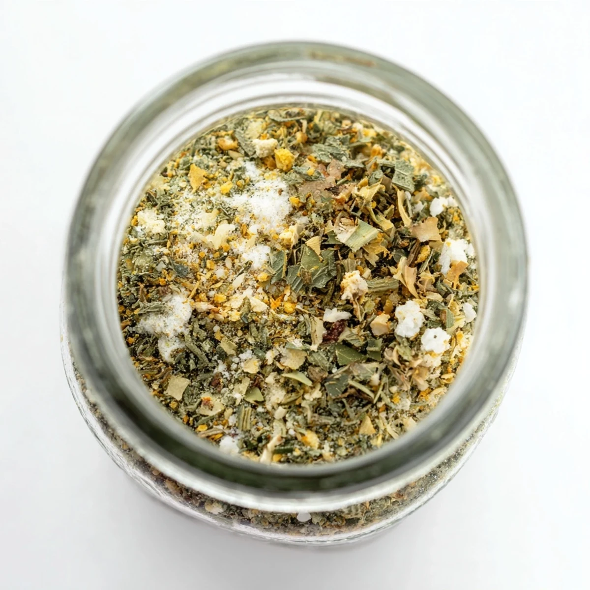 Close up spoonful of dehydrated tzatziki seasoning mix sprinkled over creamy Greek yogurt dip