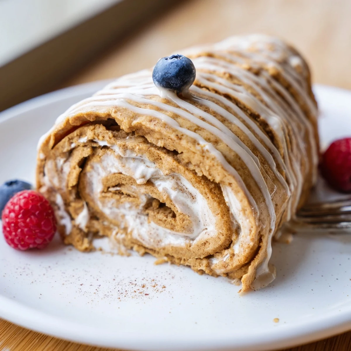 Steaming Cinnamon Roll Protein Crepes topped with light protein glaze, soft folds