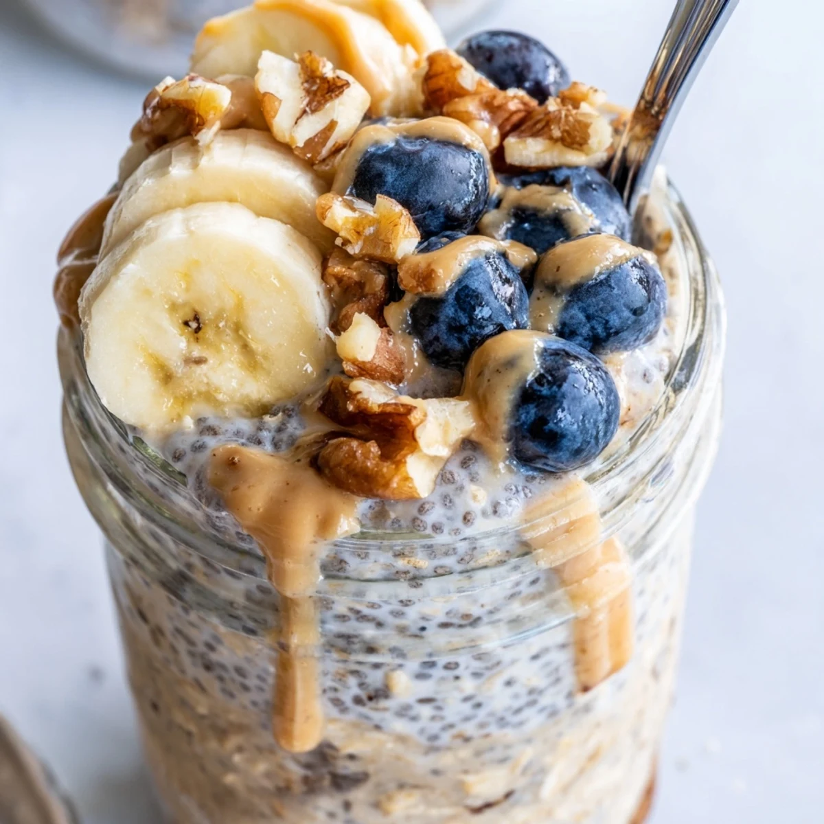 Chilled protein overnight oats layered with crunchy granola and vibrant mixed berries