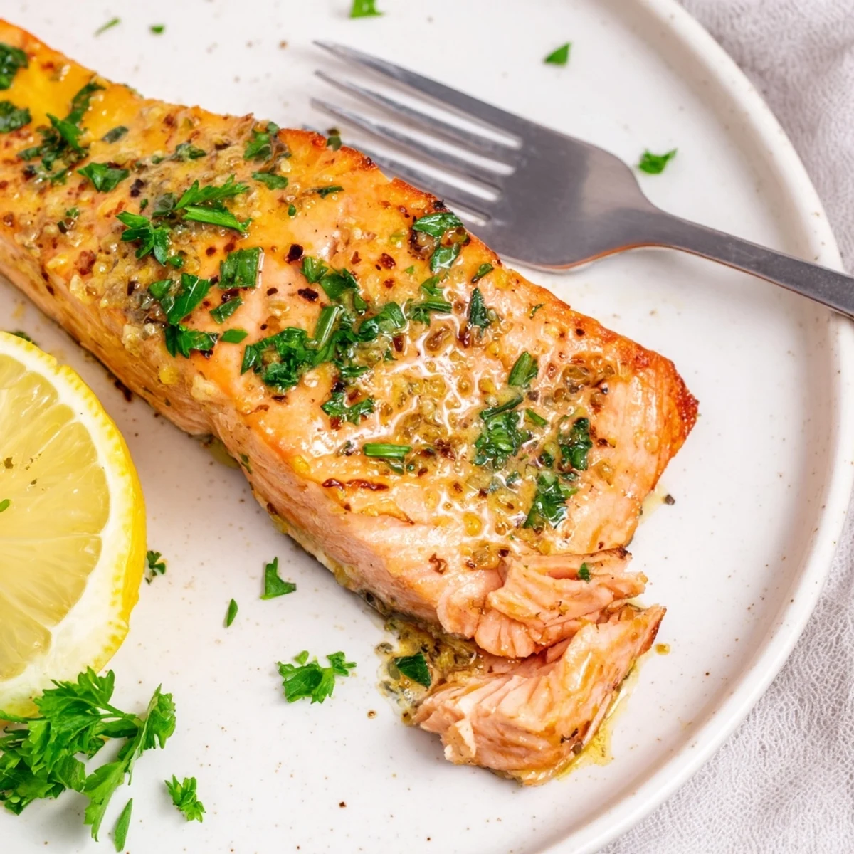Golden baked honey mustard salmon fillet glistening with a sweet tangy glaze on a parchment-lined baking sheet