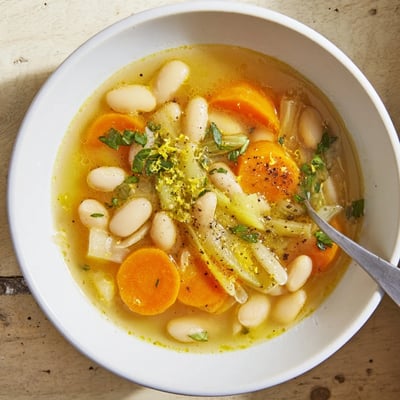 Golden carrot slices and creamy butter beans float in a savory brothy carrot butter bean soup